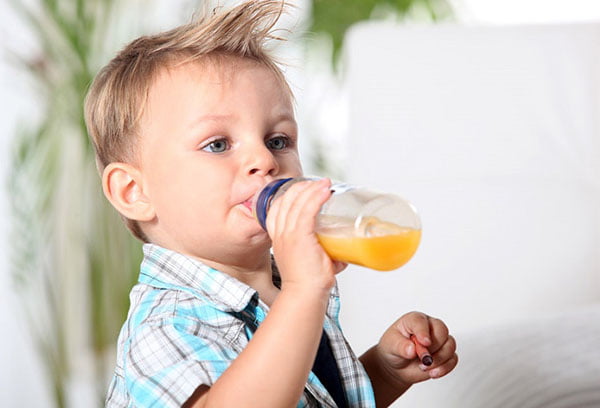 Ребенок пьет фруктовый сок